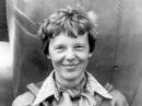 Amelia Earhart standing under nose of her Lockheed Model 10-E Electra in 1937. [National Portrait Gallery, Smithsonian Institution; gift of George R. Rinhart, in memory of Joan Rinhart]